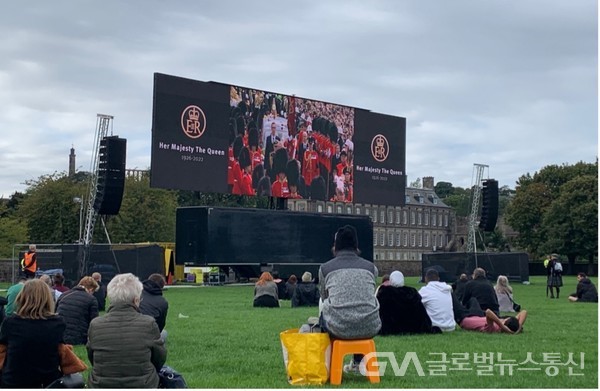 Scottish citizens pay tribute to the funeral video. Palace of Holyroodhouse in Edinburgh which is seen in the back was where the queen's coffin was enshrined.