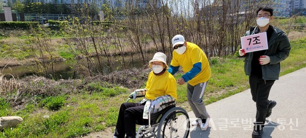(사진제공:봉주르 원주 봉사단)  이봉주 봉주르 원주 봉사단 단장(노란옷) 과 김동희 사무국장 이 휠체어를 밀면서 행사에 참여하고 있다.
