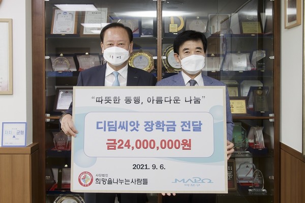 (사진제공:마포구) 지난 6일 ‘(사)희망을 나누는 사람들’ 김정안 회장이 유동균 마포구청장에게 장학금을 전달하고 기념촬영 하는 모습.
